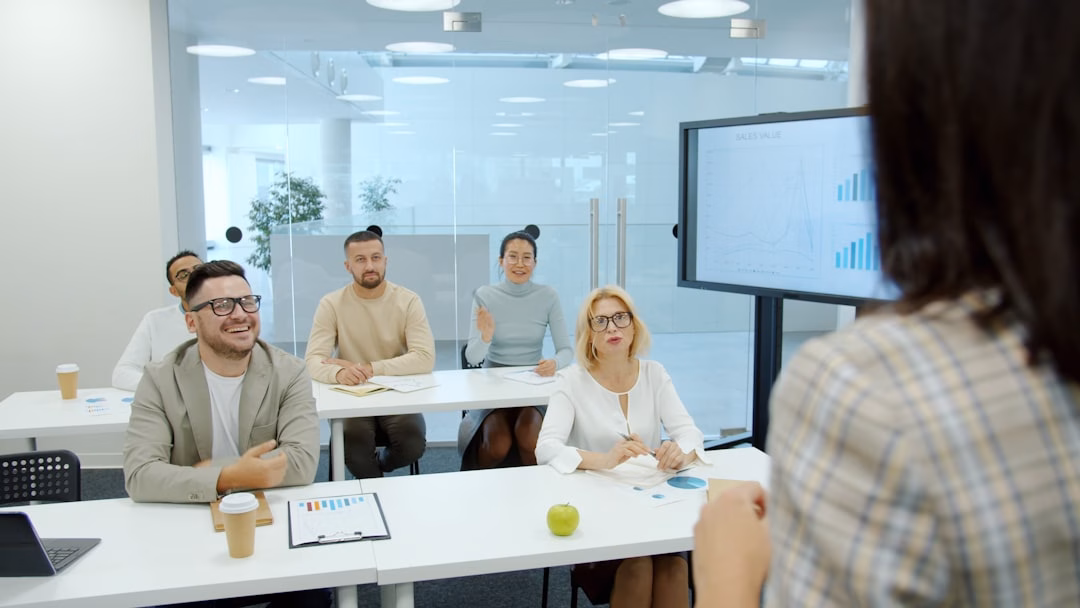 universities industry-integrated degree programs — professional mentorship session between instructor and two students in a corporate training room