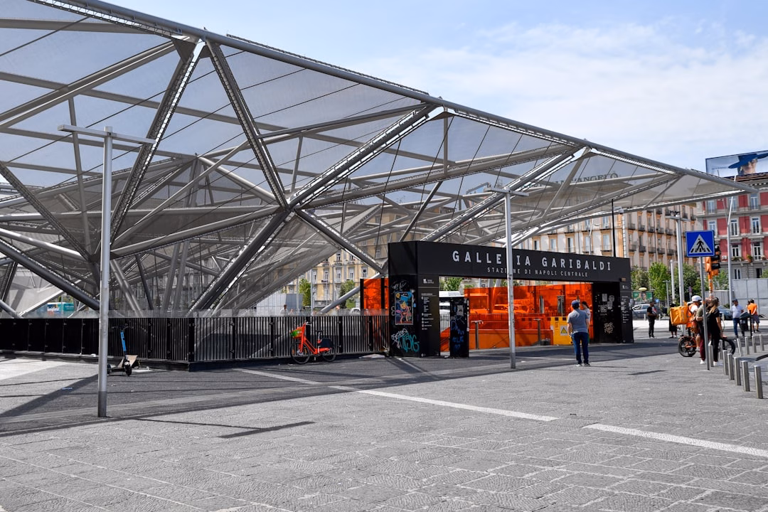 growing role mobility hubs — multimodal transport hub with bike racks, e-scooter parking, and bus shelter in urban plaza
