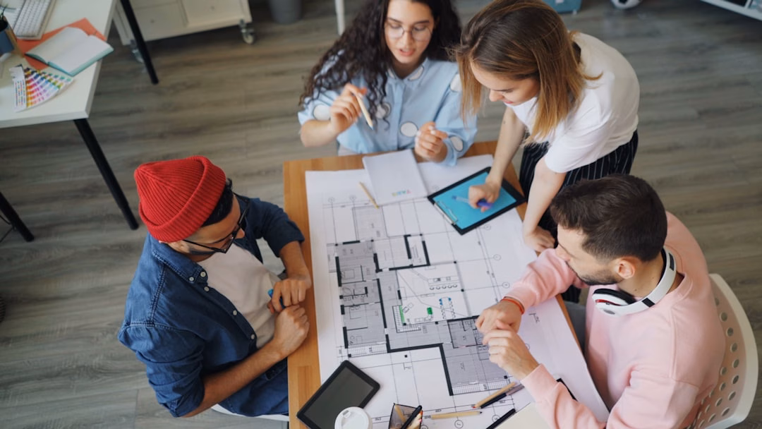 apprenticeship programs students employers — diverse group of apprentices and supervisors reviewing technical blueprint in training facility